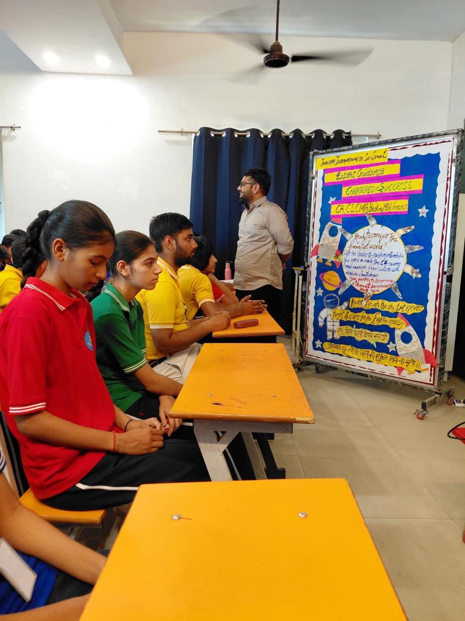Mentor guiding students beside a career-path board at Allin School